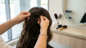 do hair extensions ruin your hair: a stylist checking root tension before fitting tape-in extensions in a Dubai salon